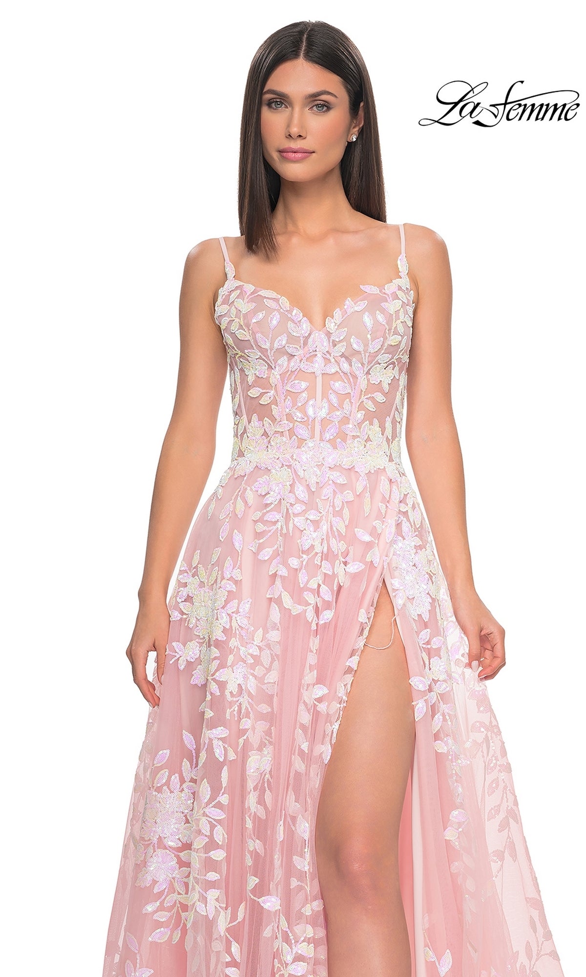 A woman models the La Femme Sequin-Print Long A-Line Prom Dress 32223, featuring a pink floral design, sheer bodice, and high slit, against a white background. The